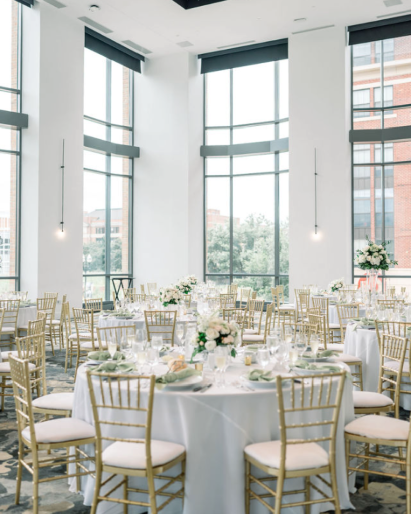Vitria on the Square wedding reception with tall windows, white floral centerpieces, sage napkins and gold chairs in Columbus.