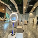 Event Captura's modern 360-style photo booth setup with a circular LED light, touchscreen display, and white equipment at an elegant indoor event venue.