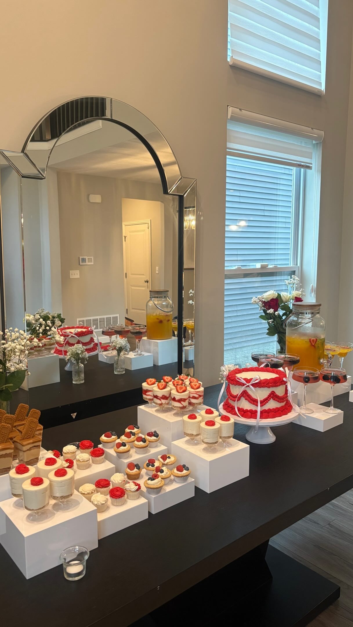 Helu Sweets Bakery custom dessert table featuring a red and white vintage-style cake, individual strawberry desserts, mini cheesecakes, cupcakes, and layered sweet treats arranged on elegant white display stands.