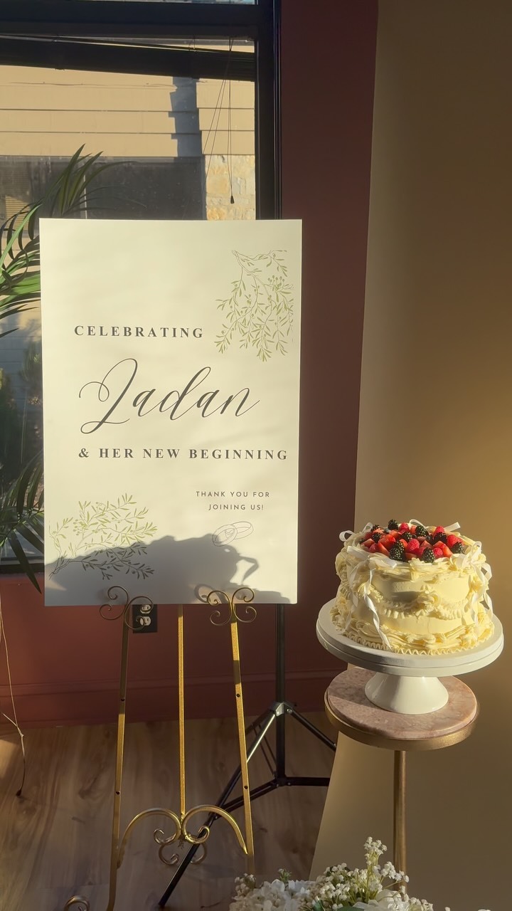 Helu Sweets Bakery custom vintage-style berry cake displayed beside a personalized bridal celebration sign featuring delicate ivory buttercream piping, white ribbon bows, and fresh mixed berries.