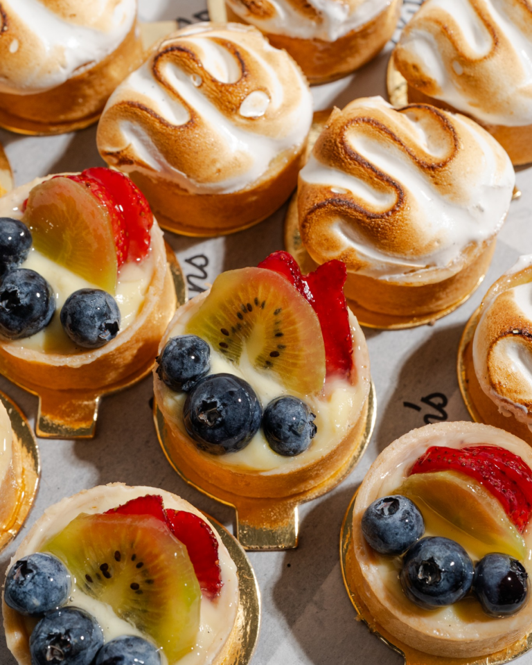 Mini fruit tarts topped with fresh blueberries, strawberries, and kiwi alongside toasted meringue tartlets from Littleton’s Market bakery.