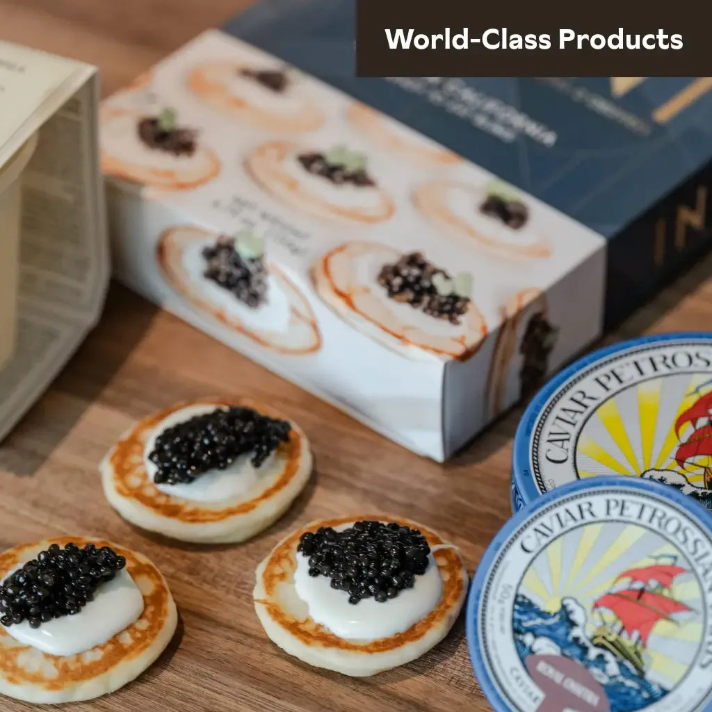 Gourmet caviar served on mini blinis with crème fraîche beside tins of Caviar Petrossian at Littleton’s Market in Upper Arlington, Ohio.