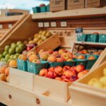 Fresh seasonal produce displayed in wooden bins at Littleton’s Market, featuring peaches, apples, pears, lemons, and other fruits.