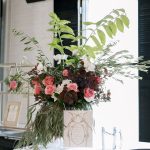 Elegant wedding floral arrangement by Market Blooms in Columbus, Ohio, featuring pink roses, white orchids, burgundy foliage, and lush greenery.