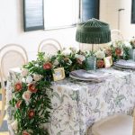 Romantic Columbus wedding reception tablescape featuring cascading pink and white florals by Market Blooms, patterned linens, green fringed lamps, and gold-framed place cards.