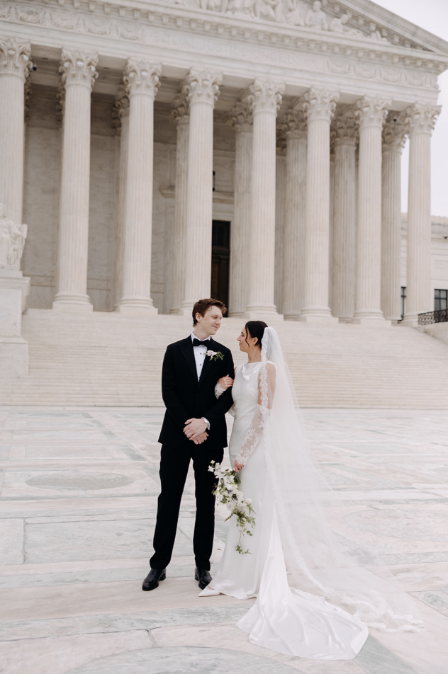 Bride & Groom in front of white marble historic building