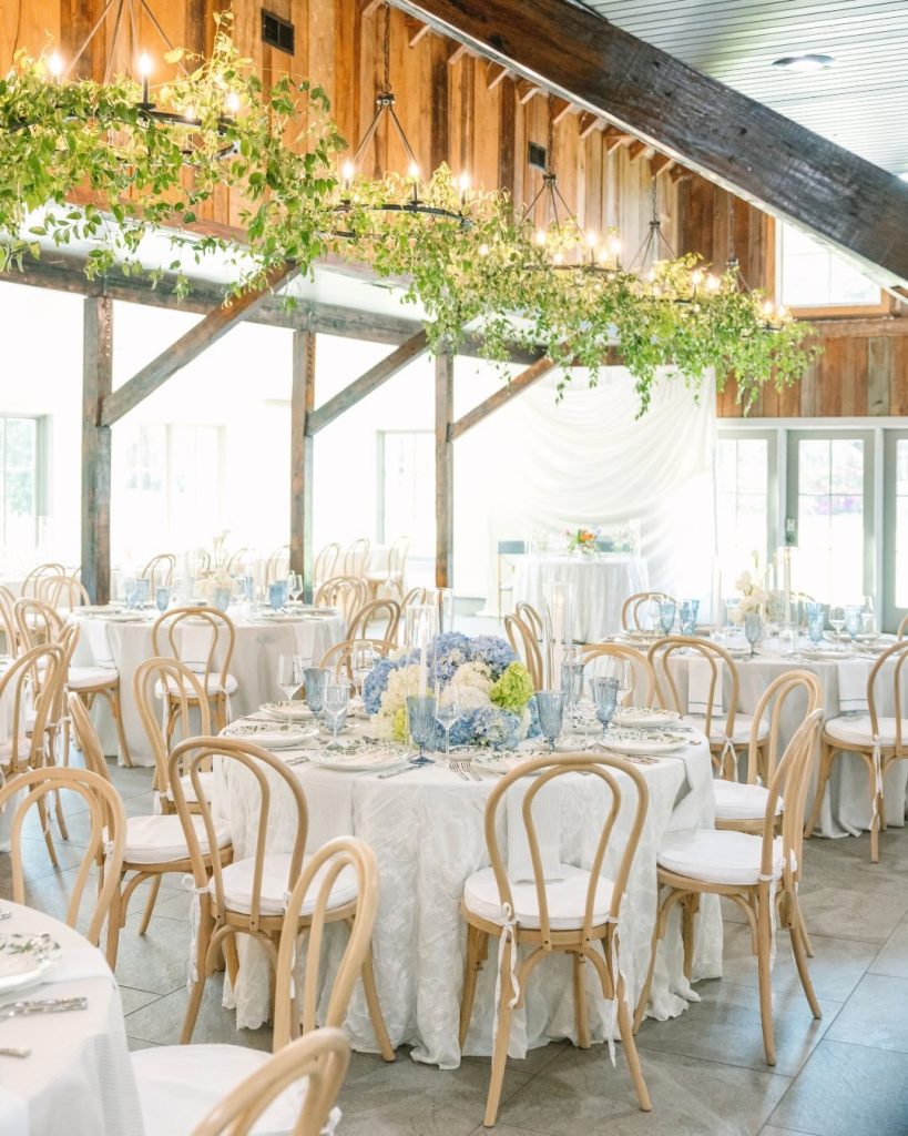 Reception pavilion at Magnolia Plantation & Gardens Events with greenery garland overhead and round tables set with white linens